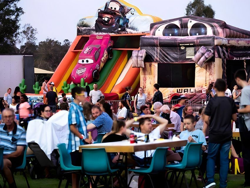 A Group of People in Front of an Inflatable Cars Slide — Fun Time Amusements in Gracemere, QLD