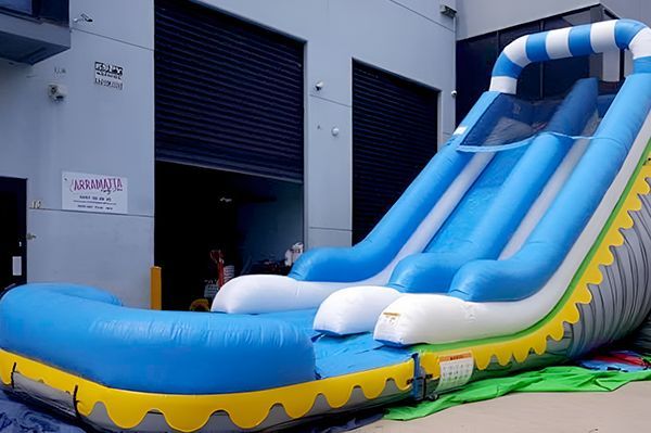 Inflatable Blue and White Water Slide With a Pool, Outside a Warehouse — Fun Time Amusements in Gracemere, QLD