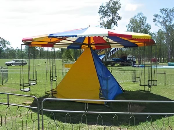 Colourful Swing Carousel in a Grassy Field — Fun Time Amusements in Gracemere, QLD