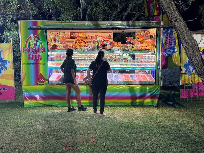 Two People at a Brightly Lit Candy Booth at Night — Fun Time Amusements in Gracemere, QLD