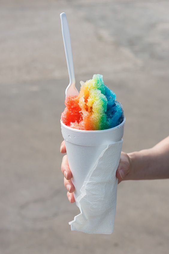 A Person is Holding a Cup of Shaved Ice With a Spoon in It — Fun Time Amusements in Emerald, QLD