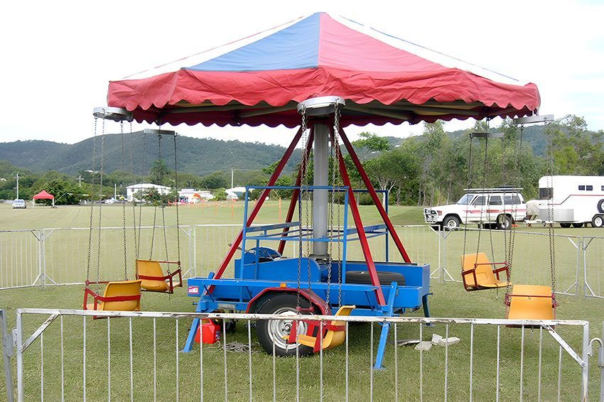 A Merry Go Round is Behind a Fence in a Field — Fun Time Amusements in Gracemere, QLD