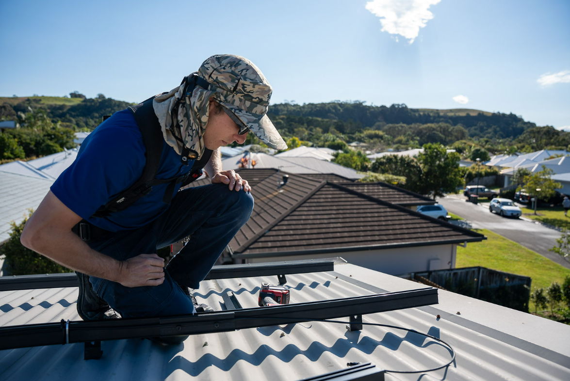 Worker Inspecting Solar Panels on A Rooftop — Local Light Electrical in Ocean Shores, NSW
