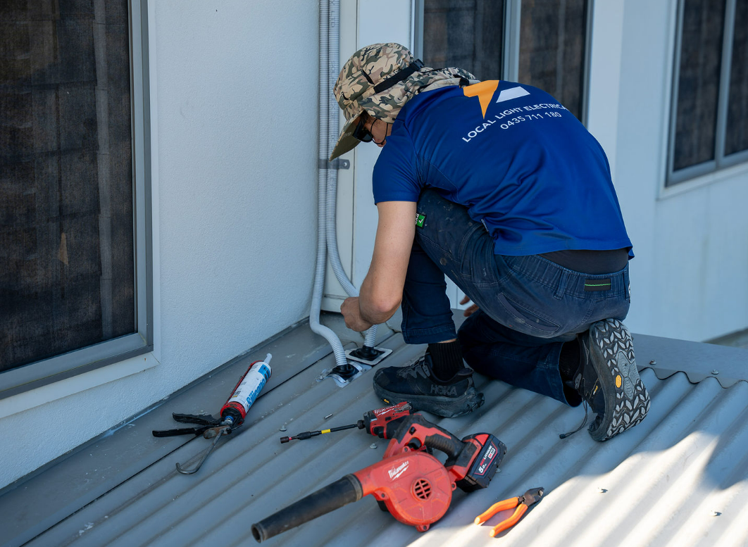 Electrician Repairing Electric Wires in Roof Top — Local Light Electrical in Suffolk Park, NSW