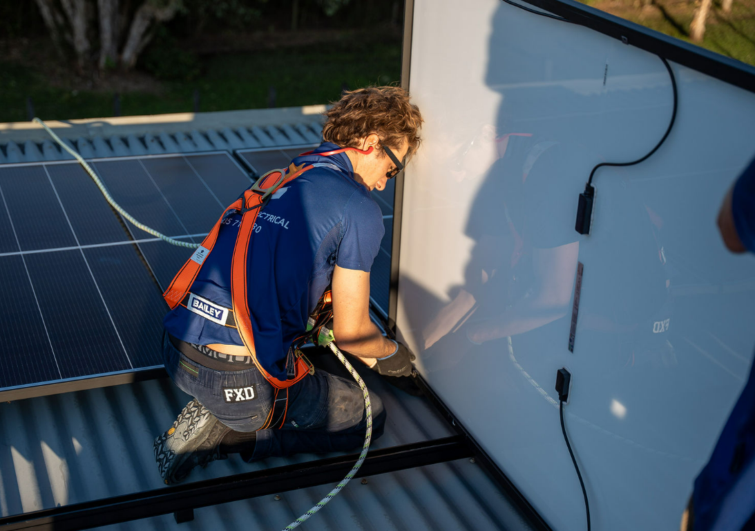 Technician Installing Solar Panels on A Rooftop — Local Light Electrical in Lismore, NSW
