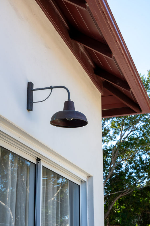Black Outdoor Wall Lamp Mounted Above a Window on a White House Exterior — Local Light Electrical in Suffolk Park, NSW