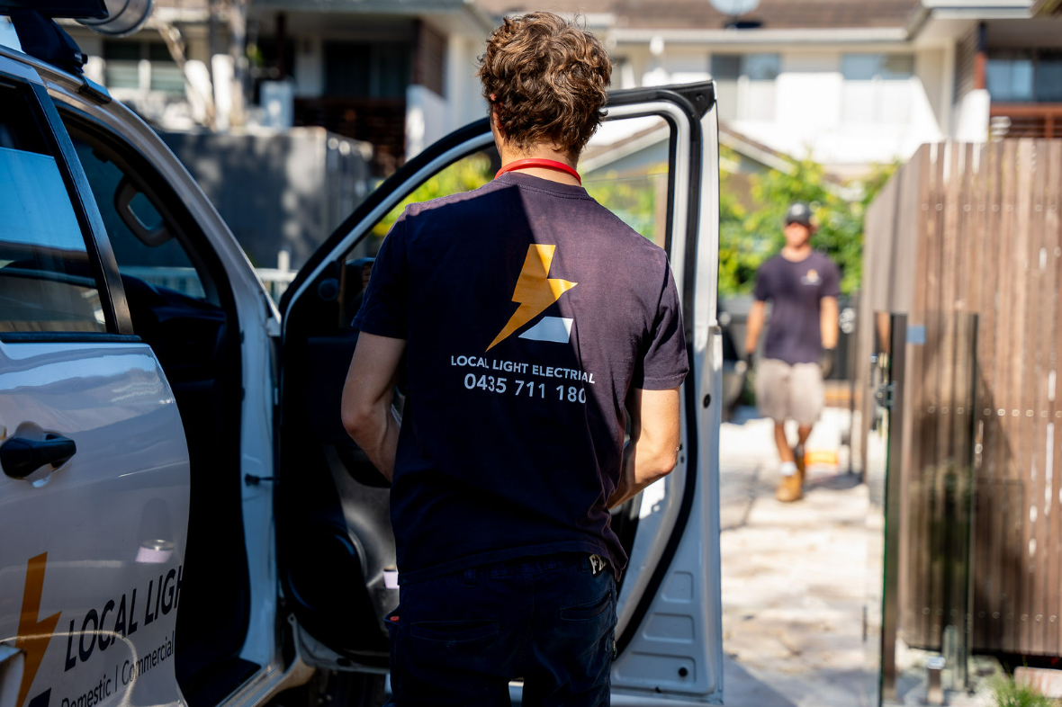 Person Unloading a Van at a Home Doorway — Local Light Electrical in Suffolk Park, NSW