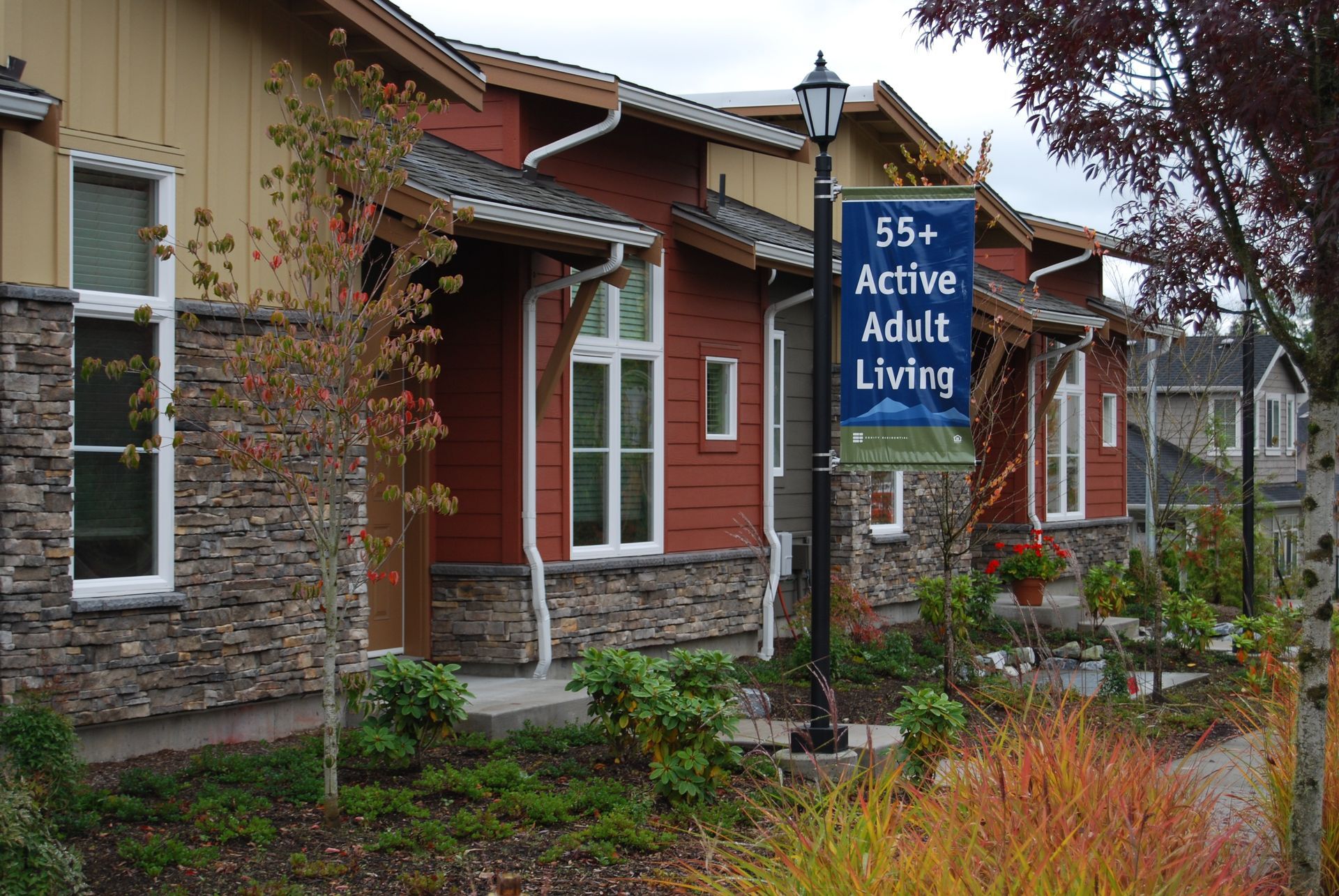 Sign for 55+ Active Adult Living outside a red brick residential building