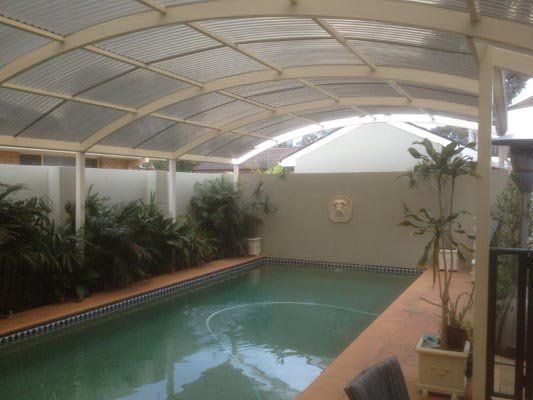 A large indoor swimming pool with a clear roof