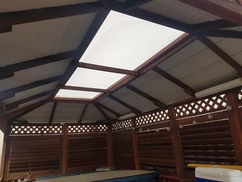 A gazebo with a roof that has a skylight in it.