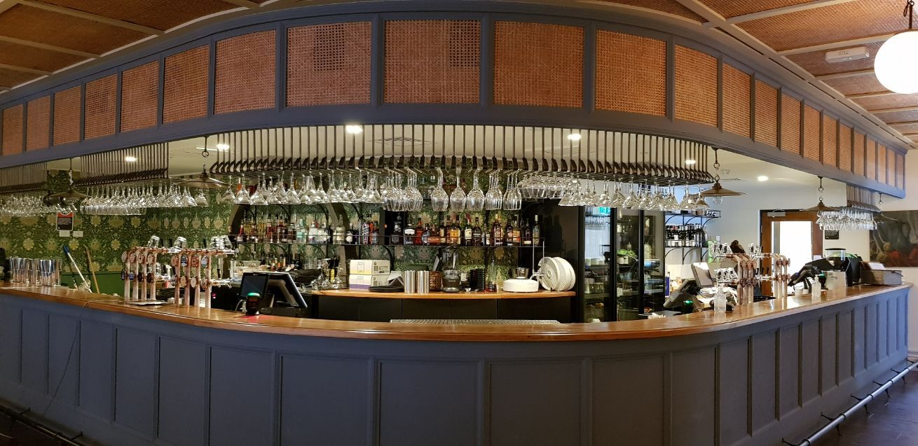 A Restaurant Booth With Green Cushions And A Wooden Floor — Logic Joinery In Fountaindale, NSW