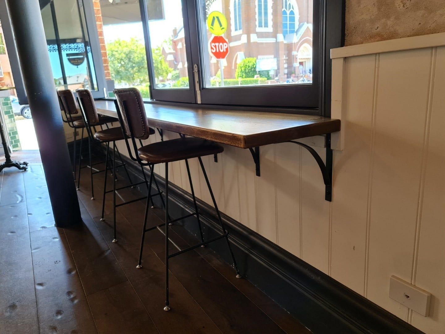 A Row Of Bar Stools Are Sitting Under A Window In A Restaurant — Logic Joinery In Fountaindale, NSW