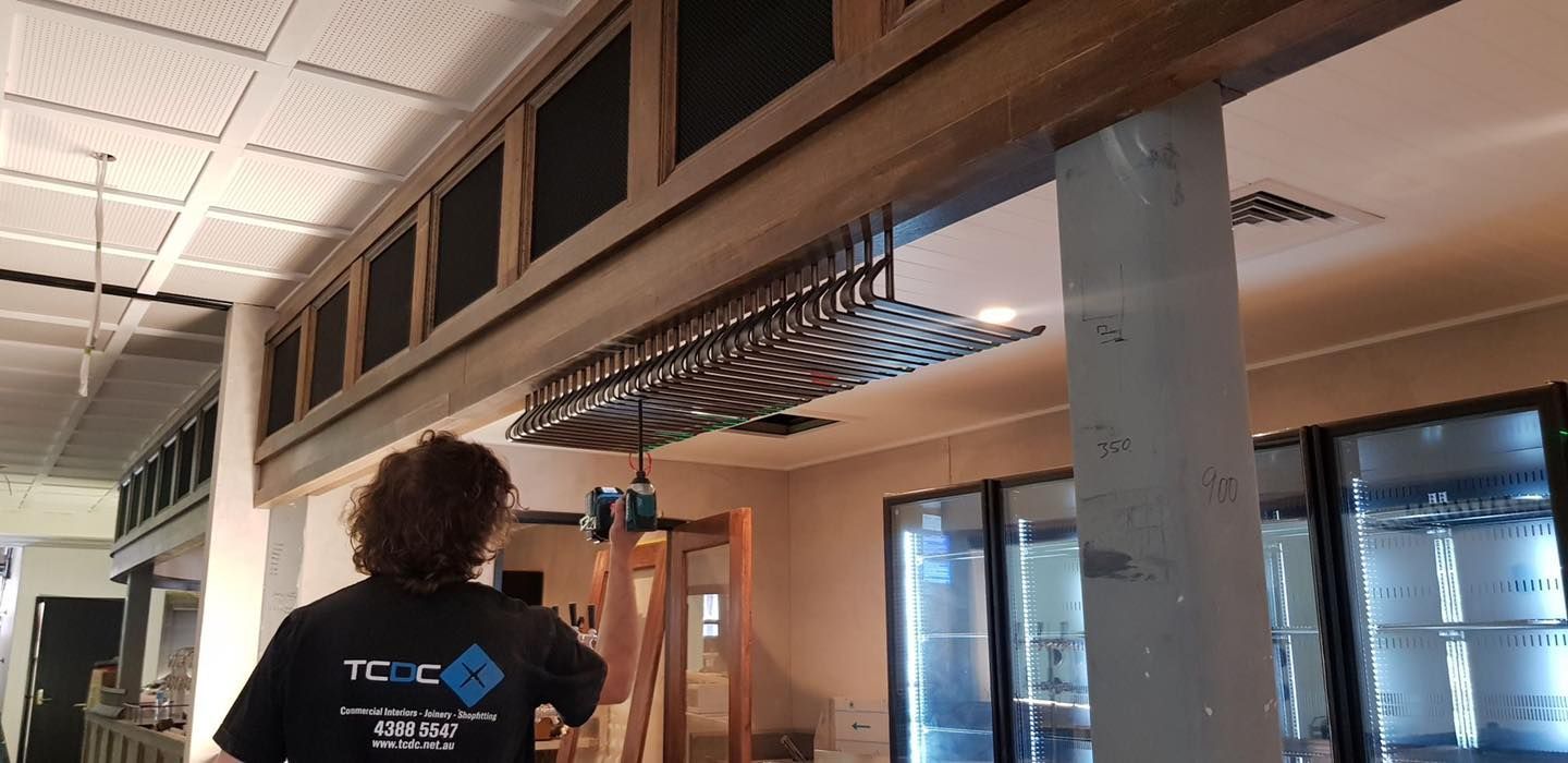 A Woman Is Standing On A Ladder In A Room — Logic Joinery In Fountaindale, NSW