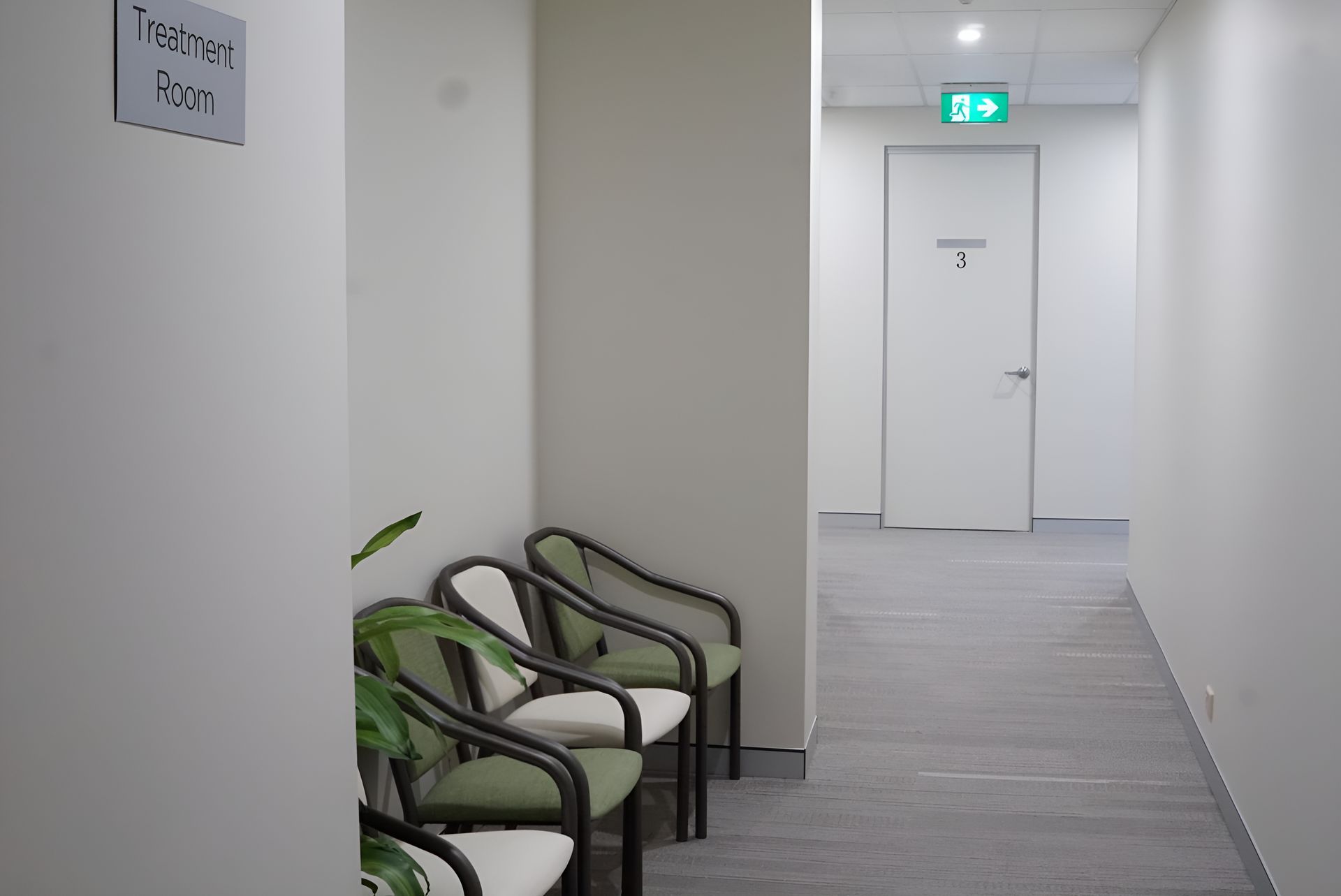 A Hallway With Chairs And A Green Exit Sign On The Wall — Logic Joinery In Fountaindale, NSW