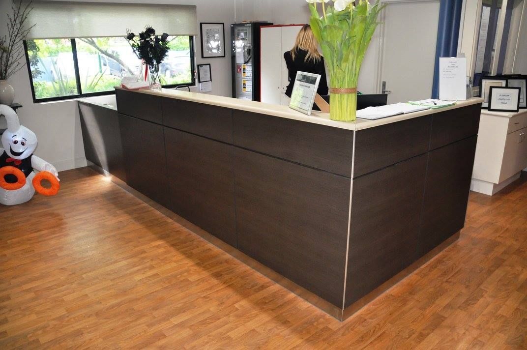 A Reception Desk With A Vase Of Flowers On Top Of It — Logic Joinery In Fountaindale, NSW