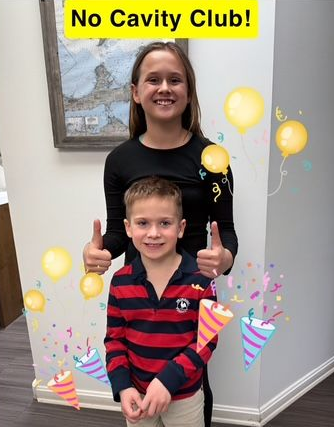Two Smiling Children Give Thumbs-Up Pose
