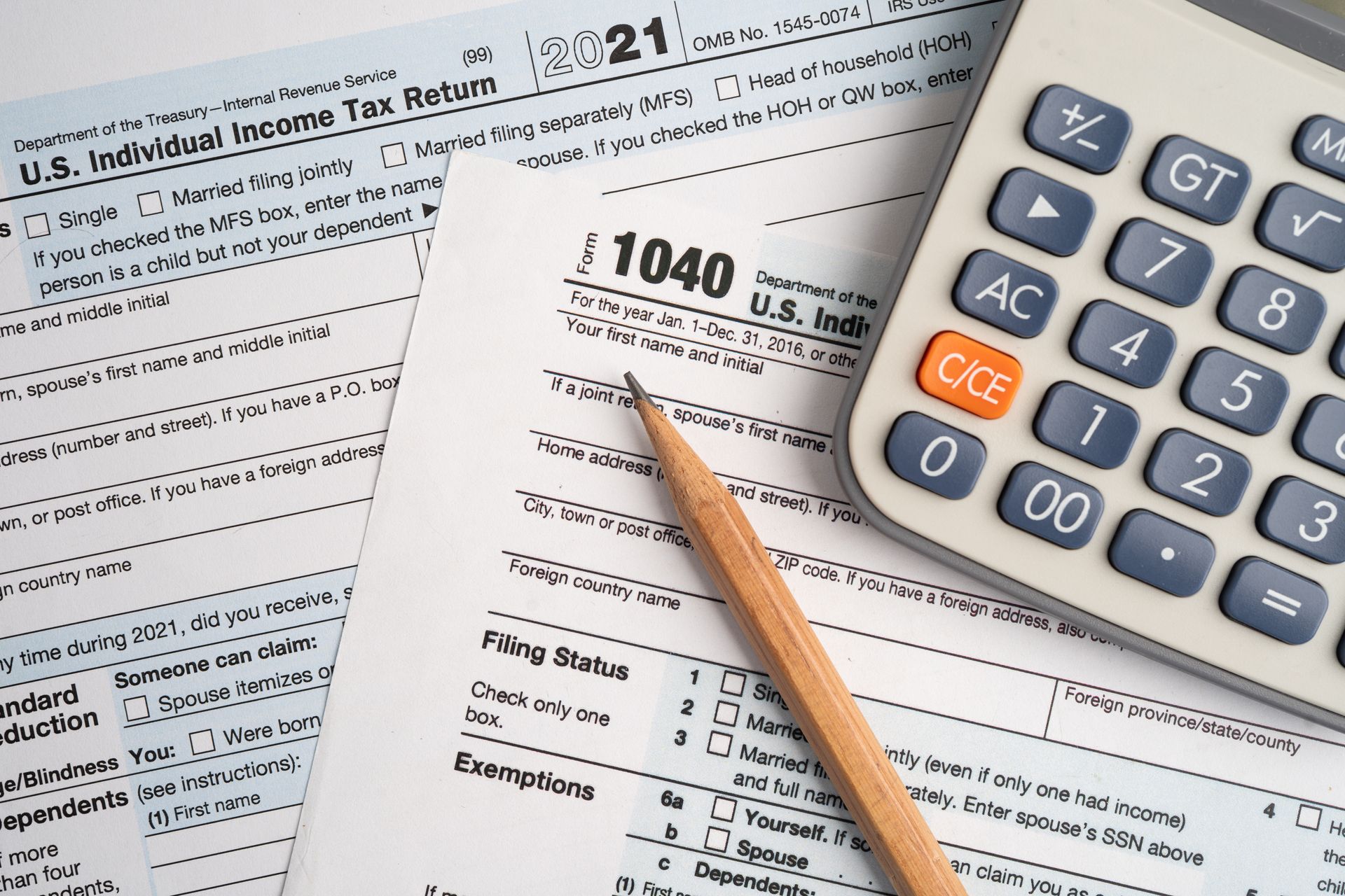 IRS Form 1040 tax return with calculator and pencil on tax documents.