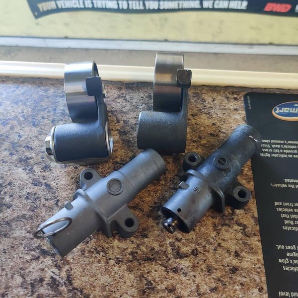 Small black metal hardware parts arranged on a speckled countertop with packaging in the background | Auto Pros