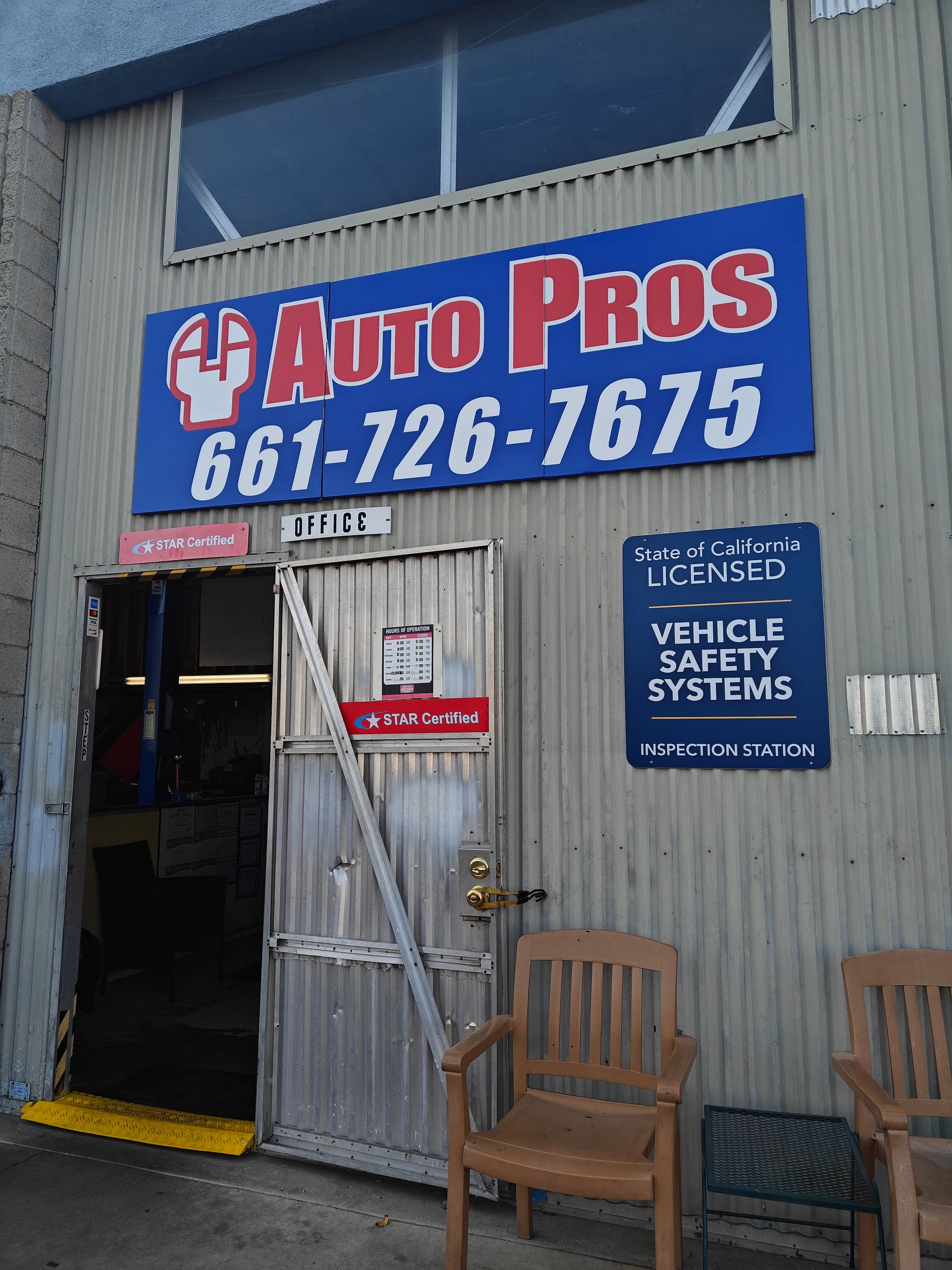 Auto Pros shop entrance with blue sign, open doorway, and chairs outside | Auto Pros