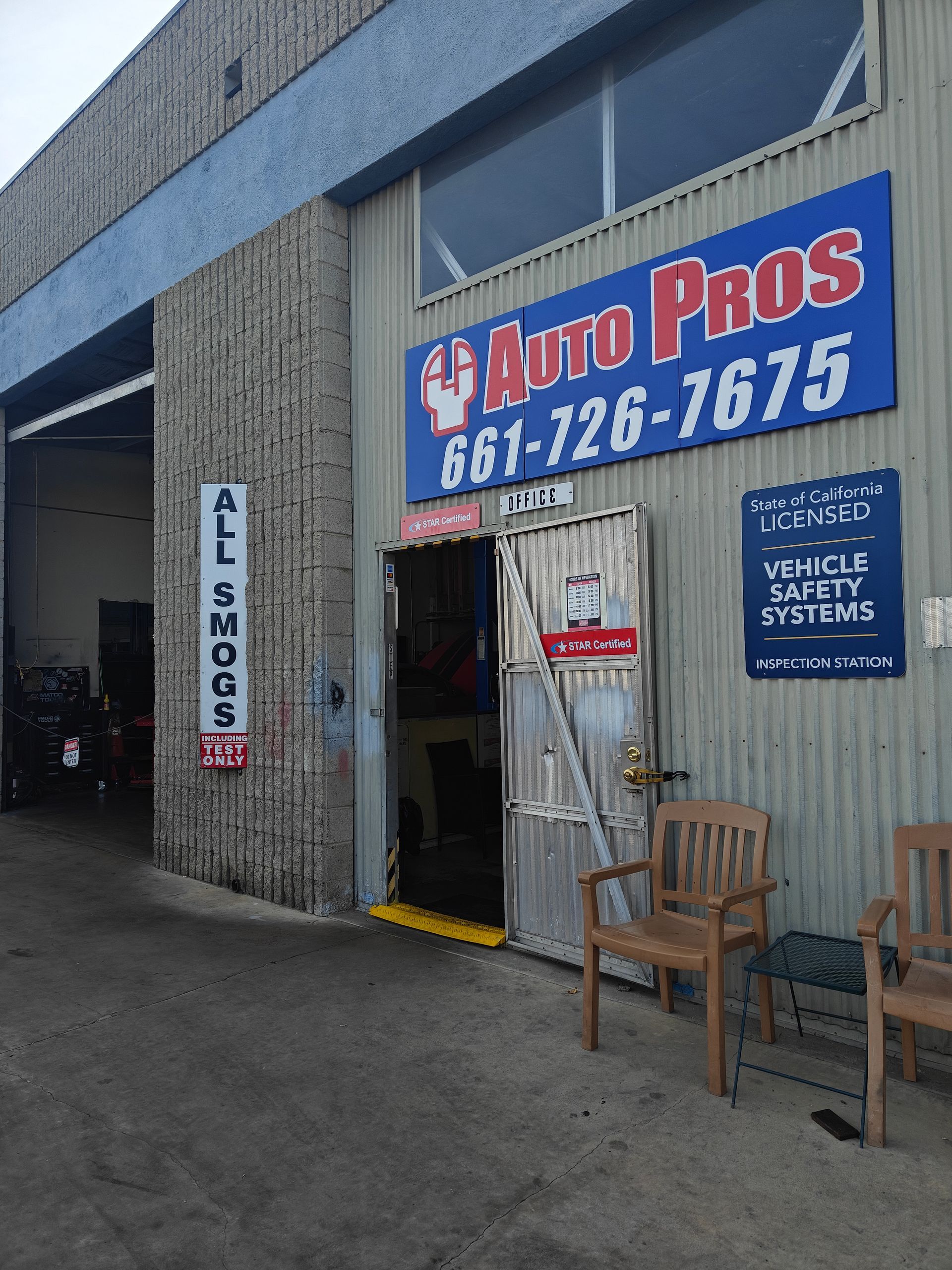 Auto Pros storefront with blue awning, open doorway, and a wooden chair outside | Auto Pros