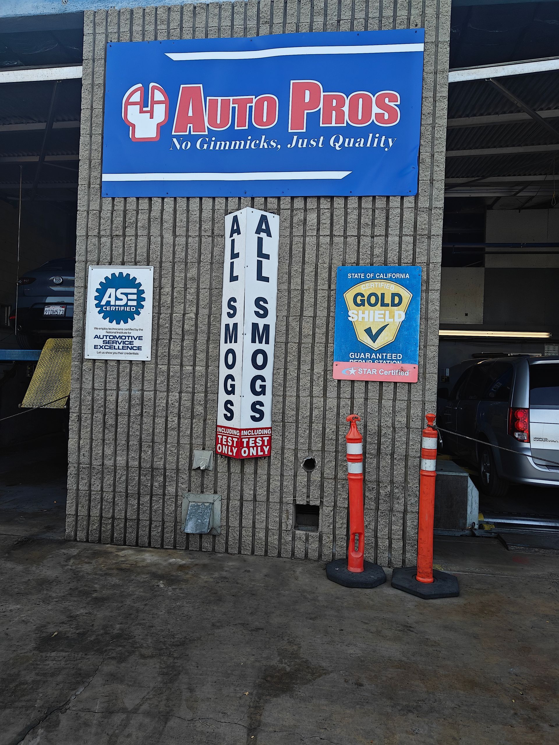 Auto Pros car wash storefront with blue sign and red bollards outside on a snowy day | Auto Pros
