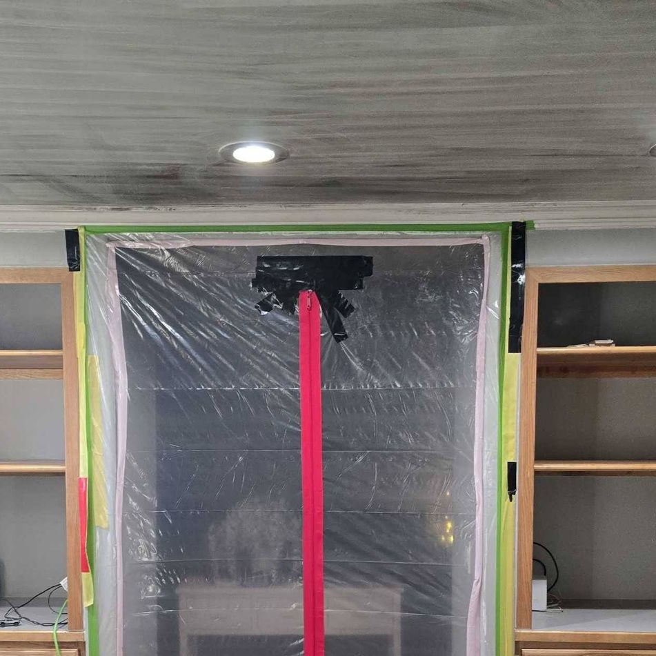 Plastic-covered doorway with a bright pink pole centered in front, indoors between shelves.