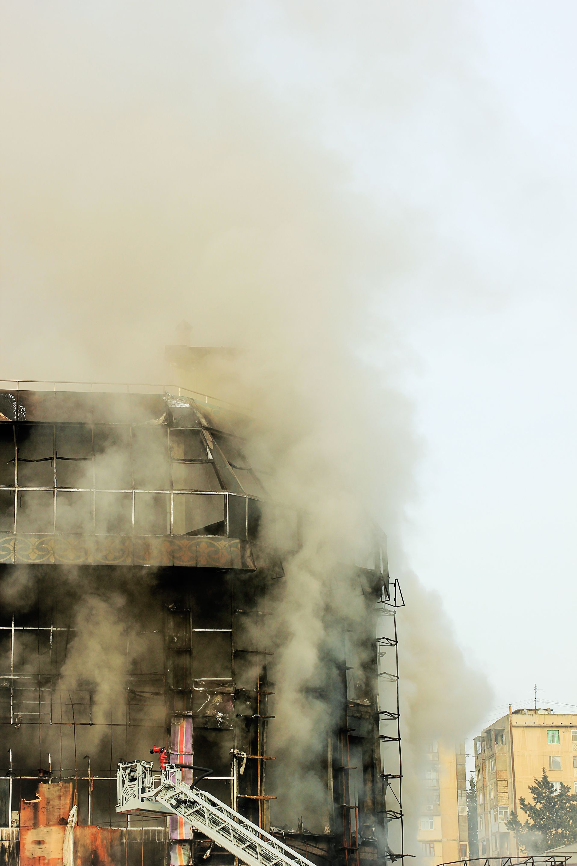 Smoke billowing from a damaged building amid heavy haze in an urban area