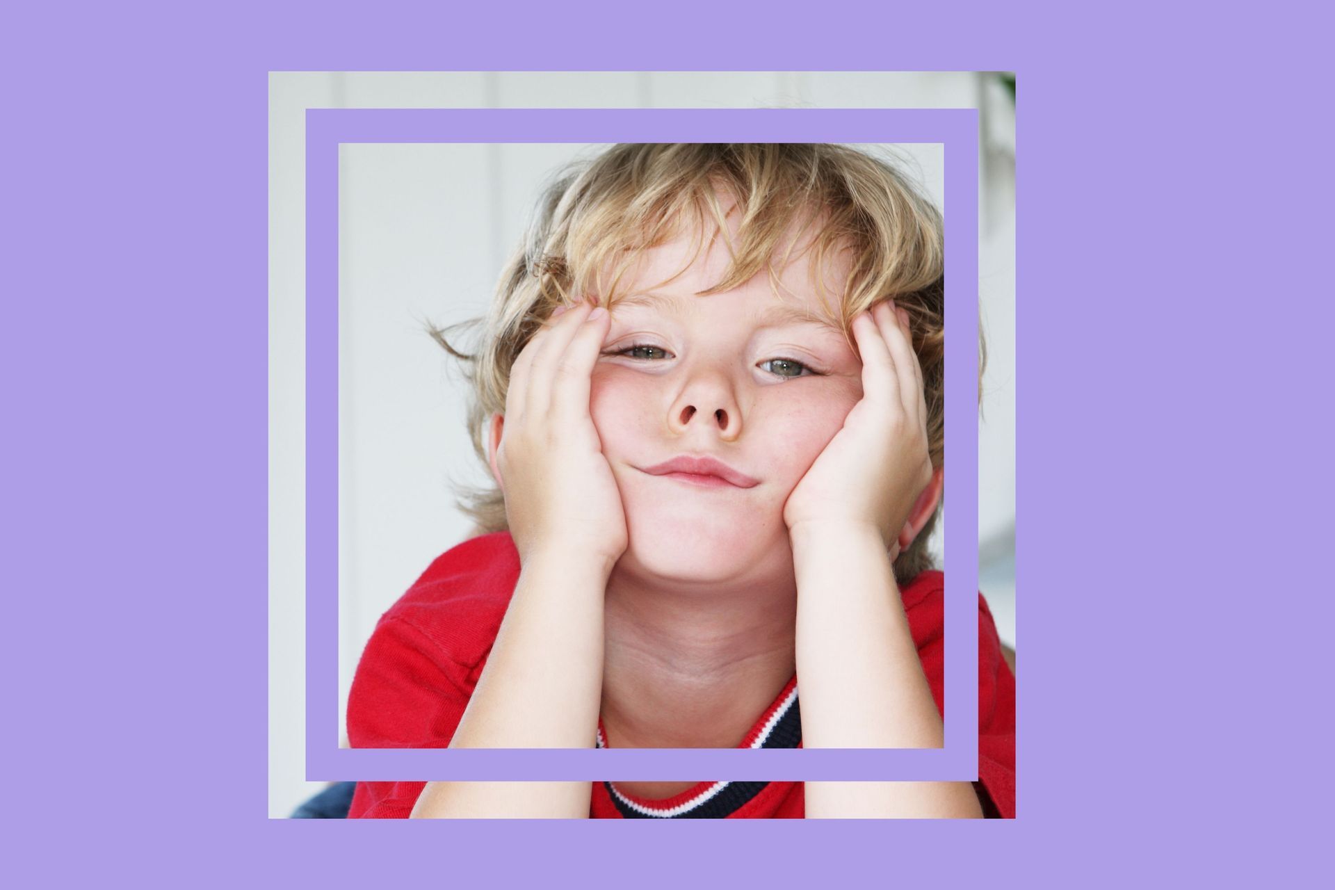 A young boy is making a boring face with his hands on his face.