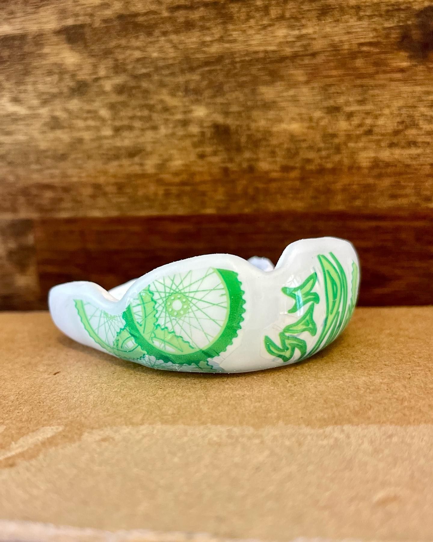 A White Mouth Guard With a Green Design — Jaw Gear Dental Prosthetics in Bowral, NSW