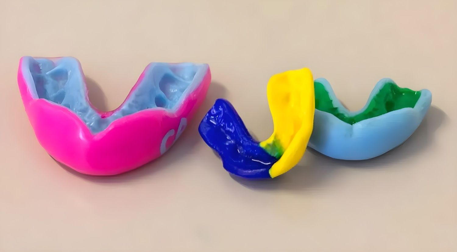 Three Colourful Mouthguards Arranged on a Light Surface — Jaw Gear Dental Prosthetics in Bowral, NSW