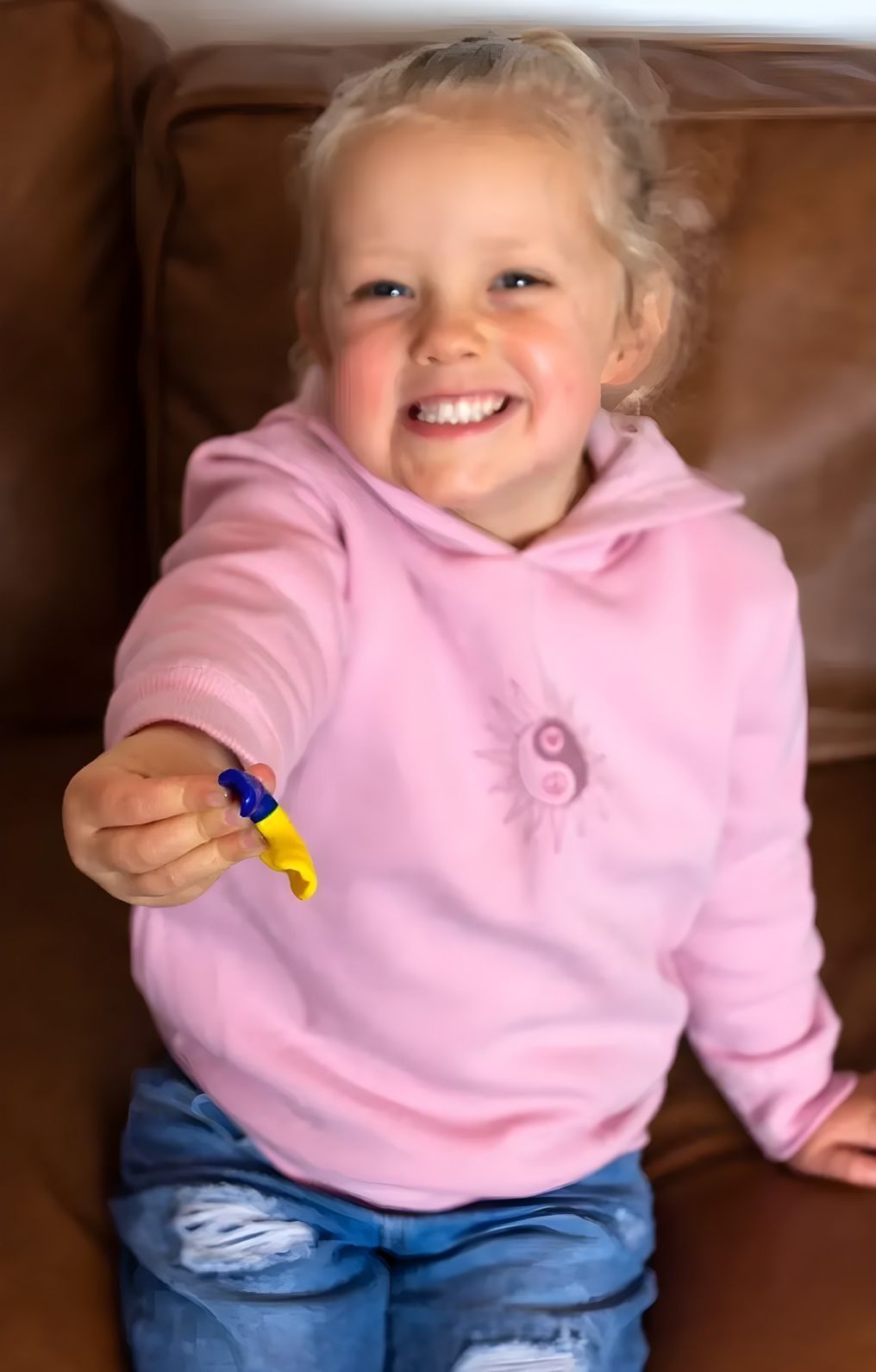 Young Girl in Pink Hoodie, Holding a Mouthguard — Jaw Gear Dental Prosthetics in Bowral, NSW