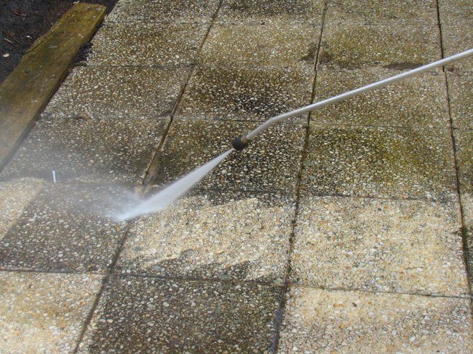 A person is writing on a clipboard in front of a house.