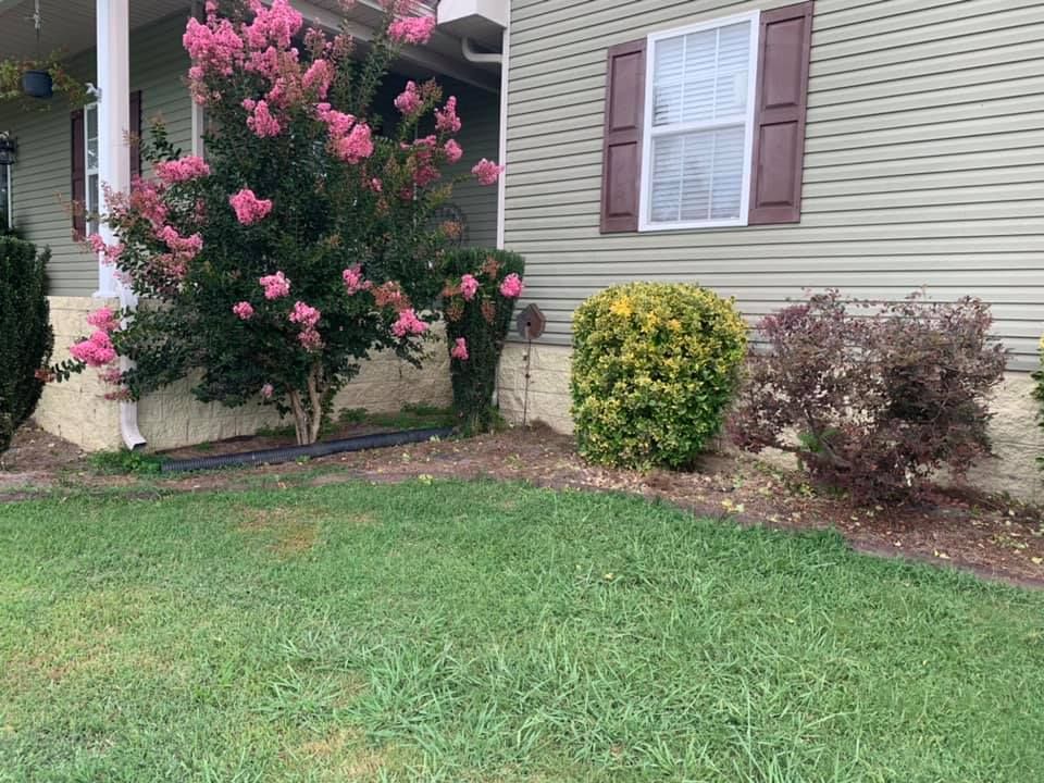 A person is writing on a clipboard in front of a house.