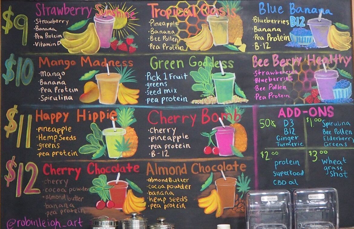 Colorful chalkboard menu listing smoothies, bowls, and add-ons with prices and fruit illustrations.