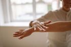 Person reaching out a hand during a yoga stretch in a bright room