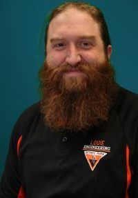 Smiling person with long red beard wearing a black polo shirt against a teal background