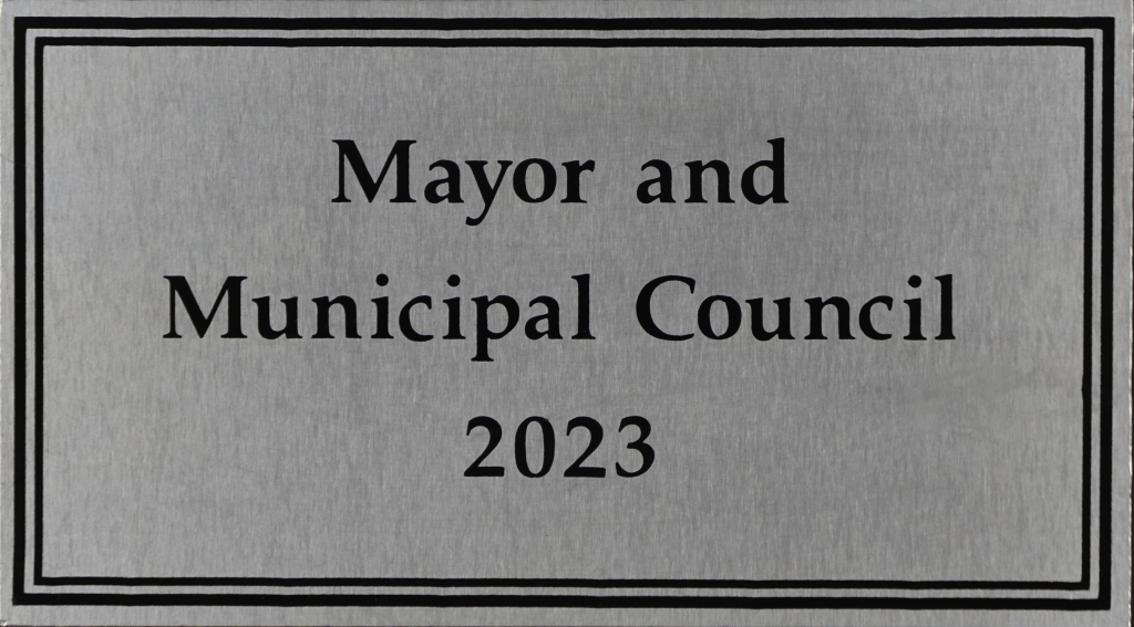 Gray plaque reading “Mayor and Municipal Council 2023” in black text.