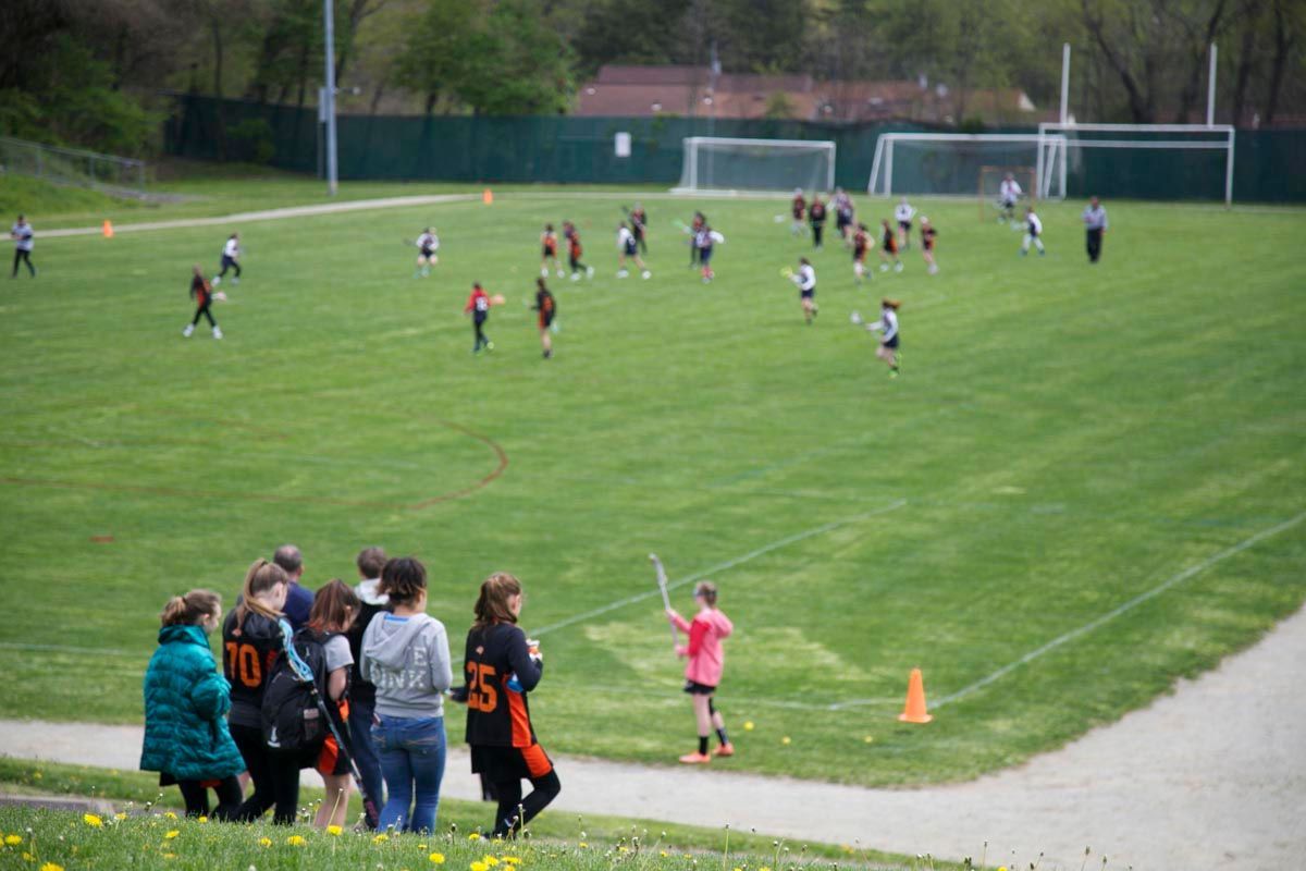 Soccer game on a grassy field with players and spectators near the sideline