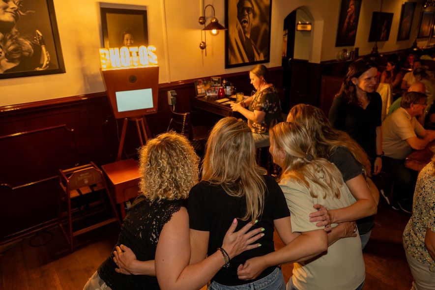 Een groep mensen die klaar staan voor een foto van de photobooth
