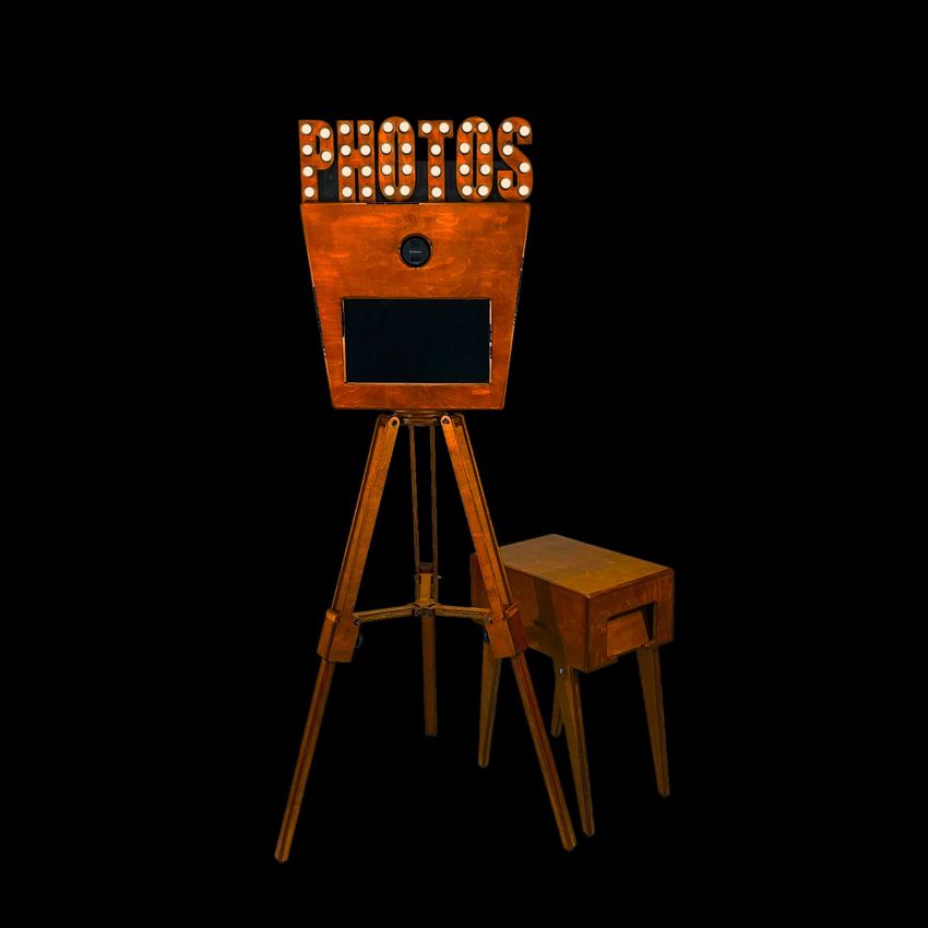 Vintage fotohokje met een oranje houten afwerking en een bijpassend kastje met printer
 tegen een zwarte achtergrond