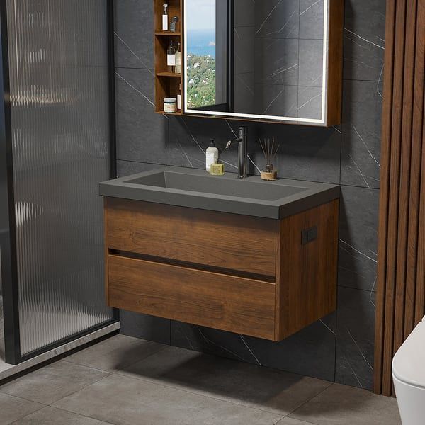 Floating bathroom vanity with wood-tone drawers, gray countertop, and a mirror with a built-in storage cabinet.