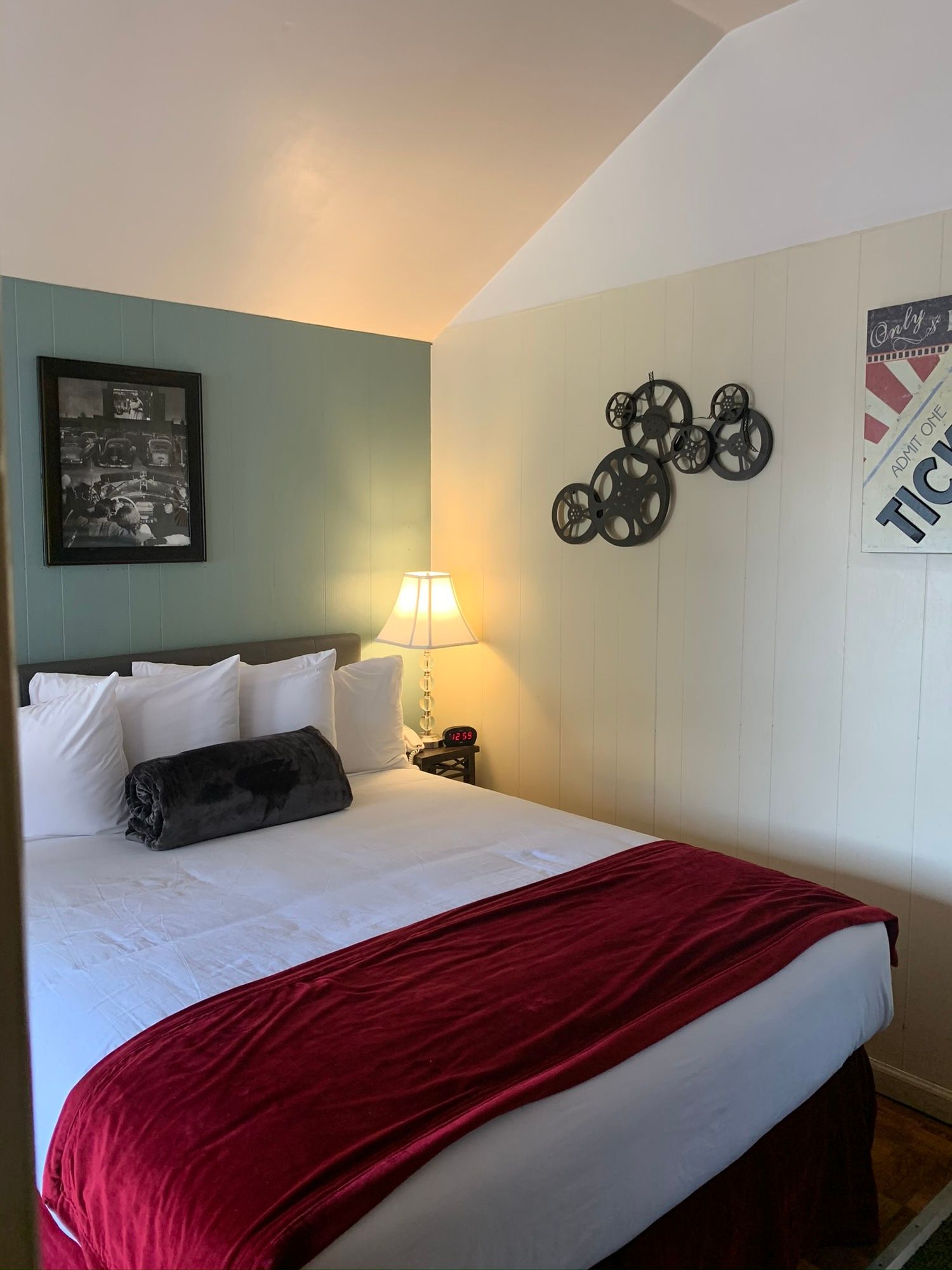 A hotel room with a king size bed and a red blanket