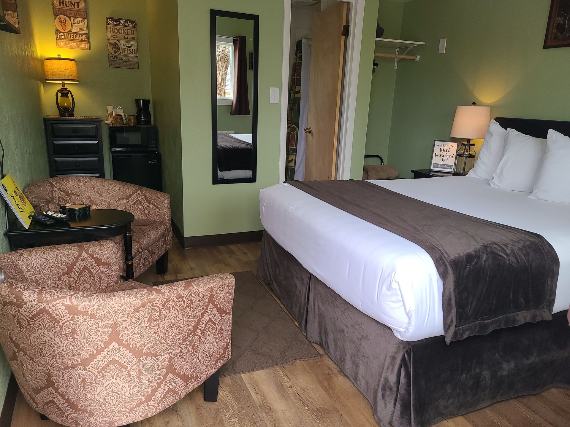 A hotel room with a king size bed and two chairs