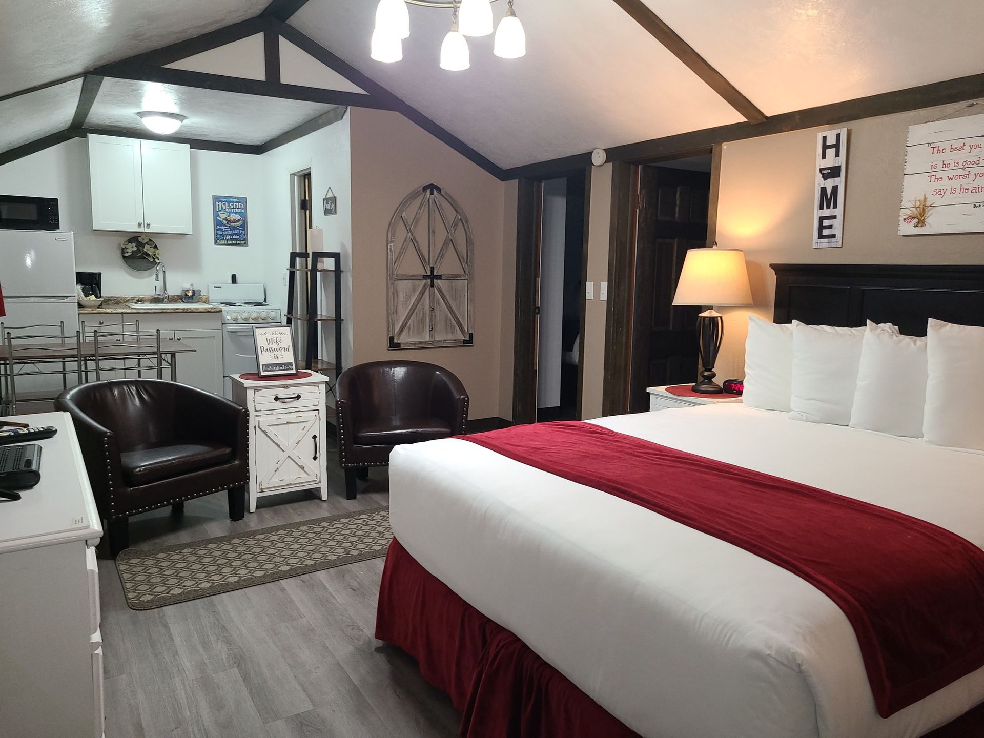 A hotel room with a king size bed and chairs