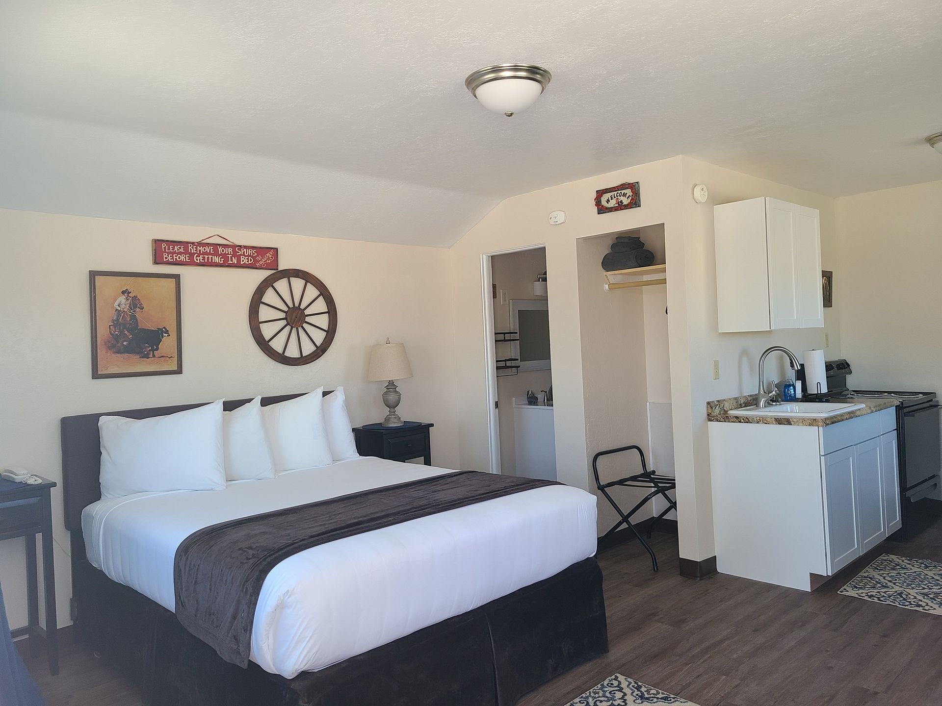 A hotel room with a king size bed and a kitchen