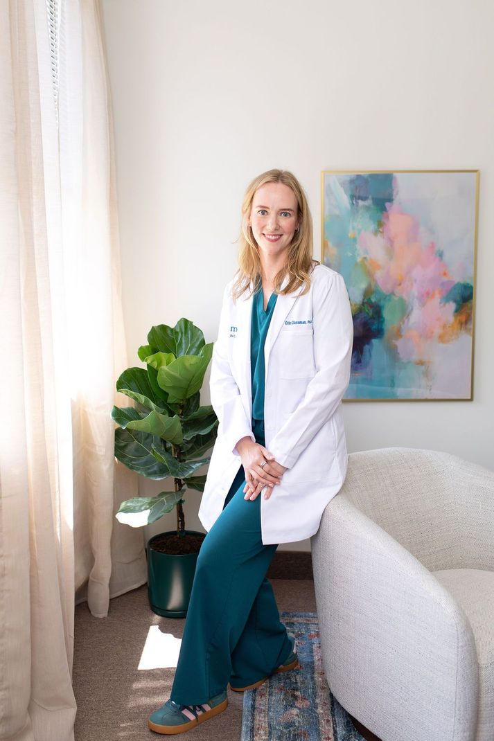 Doctor in white coat holding a clipboard and talking with a patient in a medical office