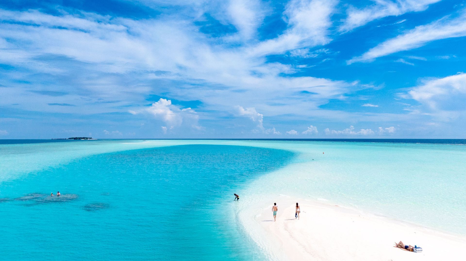 türkisfarbenes Meer mit heller Sandbank, Menschen im flachen Wasser