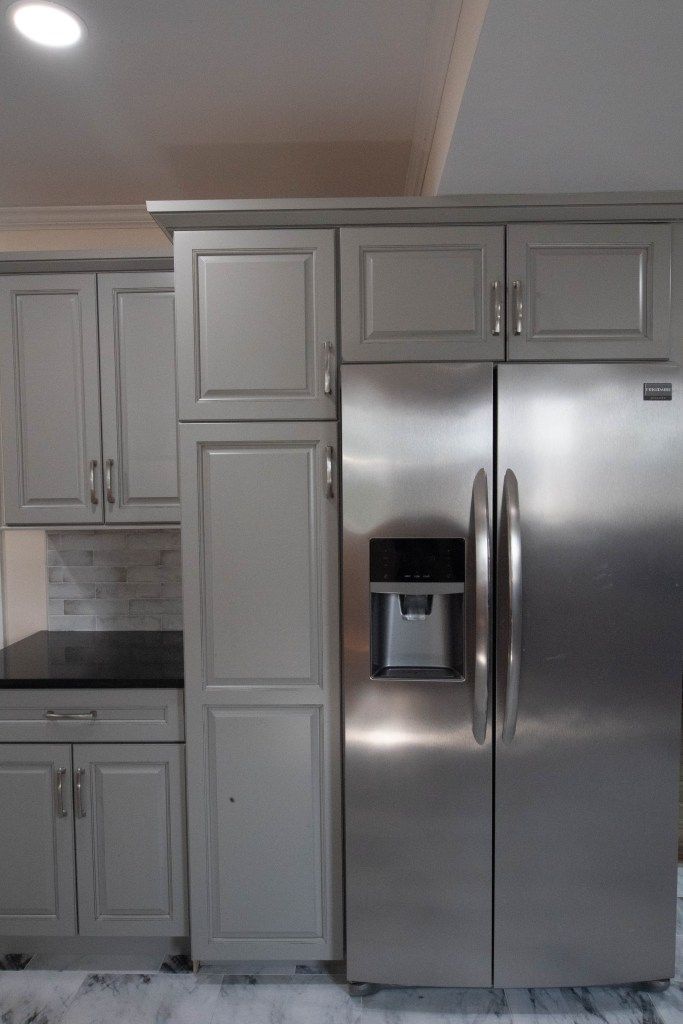 Modern kitchen with white cabinets and a stainless steel side-by-side refrigerator.