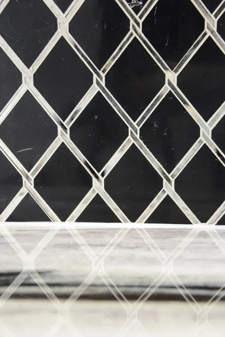 White diamond lattice fence over a dark background with a blurred white horizontal strip at the bottom