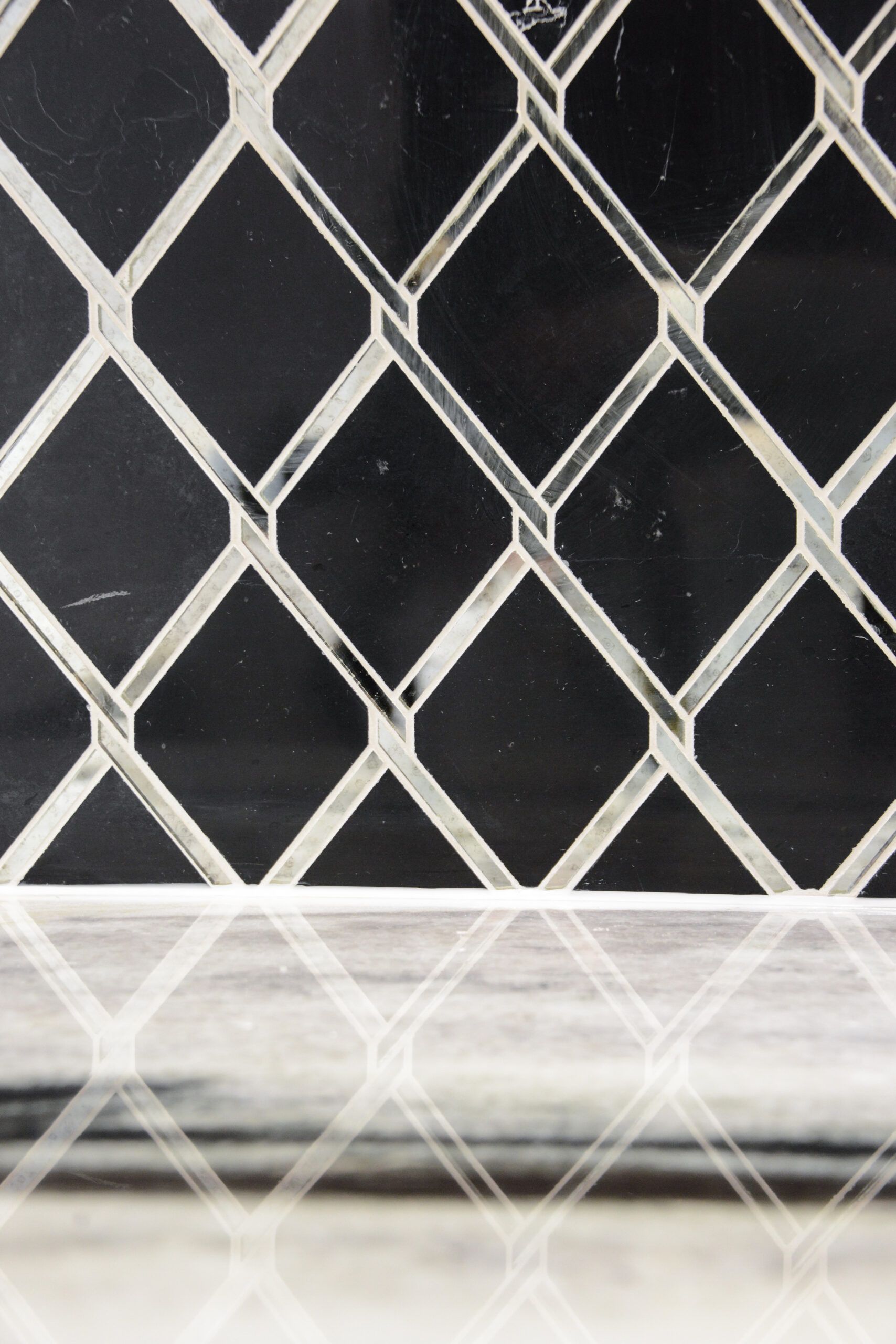 Diamond-pattern wire mesh against a dark background with a white horizontal strip at the bottom